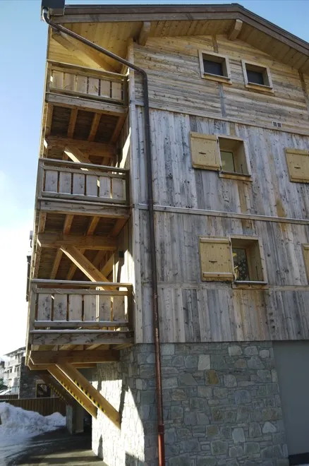 Vue extérieure du chalet, en latéral. Vue sur les balcons.