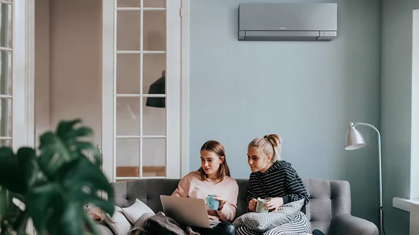 Image qui montre deux personnes dans un salon équipée d'un climatiseur Mitsubishi Electric