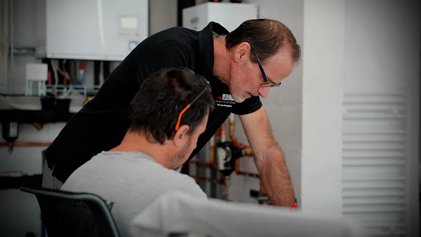 Image qui montre un formateur Mitsubishi Electric avec un élève pendant une formation Qualipac