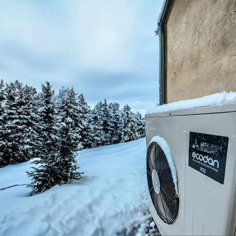 Image qui montre le groupe extérieur d'une pompe à chaleur Air-Eau en plein hiver enneigé